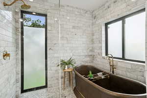 Bathroom with tile walls, a freestanding bath, and tile patterned floors