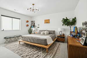 Bedroom featuring a chandelier and carpet