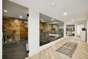 Exercise area featuring wood walls, recessed lighting, and wood finished floors