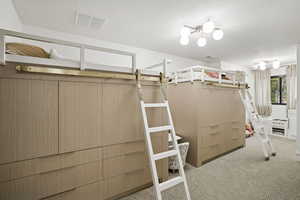 Bedroom featuring carpet and a textured ceiling