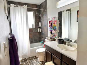 Full bathroom featuring shower / bathtub combination with curtain, vanity, and light tile patterned flooring