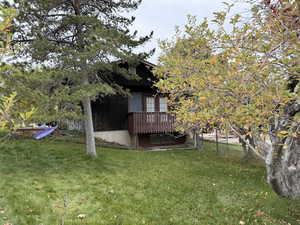 View of grassy yard with a deck