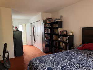 Bedroom with a textured ceiling and a closet