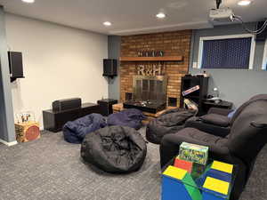 Carpeted living area with recessed lighting and a brick fireplace