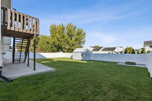 Fenced backyard with a pergola, a deck, a patio area, and an outdoor fire pit