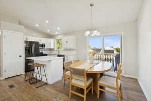 Dining area featuring lofted ceiling, recessed lighting, a chandelier, and light wood-style floors