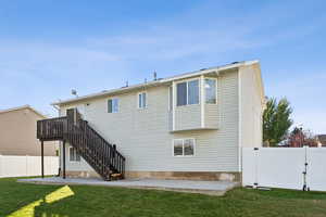 Rear view of property with a fenced backyard, a patio, stairway, and a gate