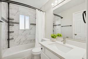 Bathroom with vanity and shower / bath combination with curtain