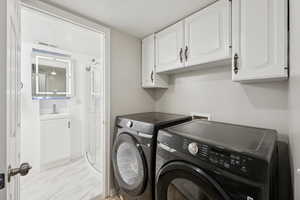 Laundry area featuring cabinet space and washing machine and clothes dryer