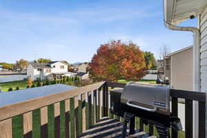 Wooden deck with a grill, a residential view, and a fenced backyard
