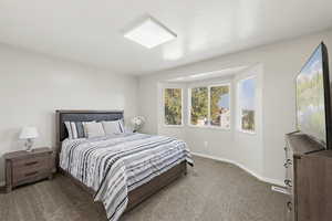 Bedroom featuring carpet and baseboards