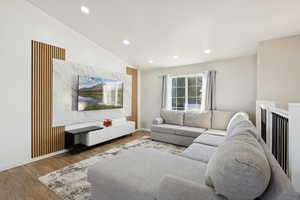 Living area featuring vaulted ceiling, wood finished floors, and recessed lighting