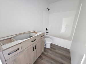 Full bathroom featuring dark wood-style flooring, vanity, and shower / bath combination