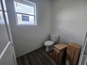 Bathroom featuring dark wood-type flooring and toilet