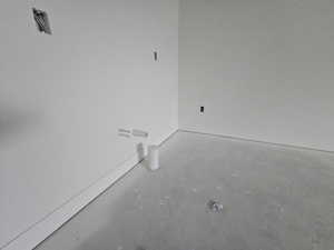 Empty room with unfinished concrete flooring