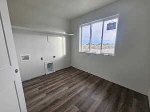 Laundry area featuring dark wood-style floors, hookup for a washing machine, and electric dryer hookup