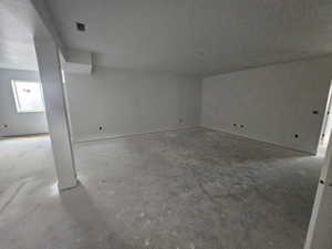Empty room with unfinished concrete flooring