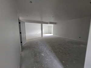 Empty room with concrete floors and a textured ceiling
