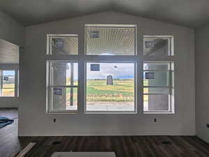 Entrance foyer with dark wood-type flooring, lofted ceiling, and plenty of natural light