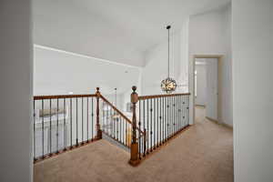 Corridor with carpet and high vaulted ceiling