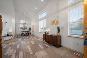 Office area featuring high vaulted ceiling, light wood-type flooring, recessed lighting, and a chandelier