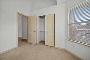 Unfurnished bedroom featuring light carpet and a closet