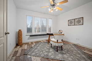 Home office with light wood-style floors and ceiling fan