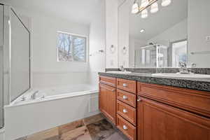 Bathroom with a garden tub, double vanity, and a shower stall