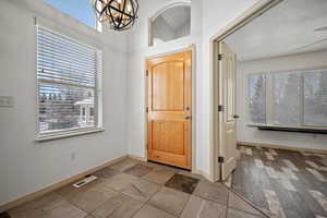 Foyer entrance featuring baseboards and a chandelier