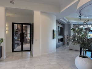 Hall featuring ornamental molding and light tile patterned floors