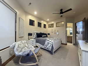 Bedroom with a ceiling fan, ensuite bathroom, light carpet, and recessed lighting