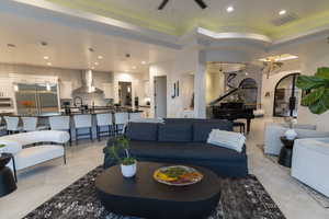 Living room featuring recessed lighting, a tray ceiling, and arched walkways