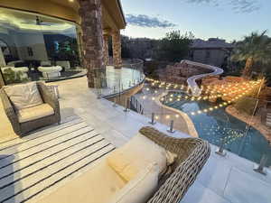 View of swimming pool with a water slide and a patio area