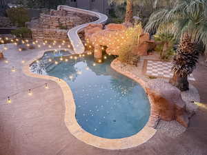 Swimming pool with a patio area, a water slide, and a jacuzzi