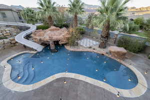View of swimming pool featuring a water slide, a patio, and a fenced backyard