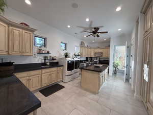 Kitchen featuring a kitchen island, open shelves, recessed lighting, washer and dryer, and light tile patterned flooring