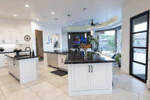 Kitchen featuring decorative light fixtures, white cabinetry, a tray ceiling, a ceiling fan, and recessed lighting