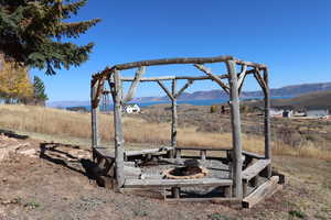 View of yard with a mountain view, an outdoor fire pit, and a view of countryside