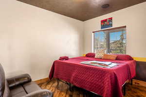 Bedroom featuring hardwood / wood-style flooring and baseboards