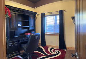 Office featuring baseboards and dark colored carpet