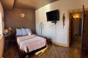 Bedroom with baseboards and hardwood / wood-style flooring