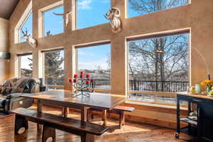Dining area featuring a high ceiling, plenty of natural light, and hardwood / wood-style flooring