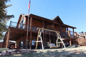 Back of property featuring a deck and a patio