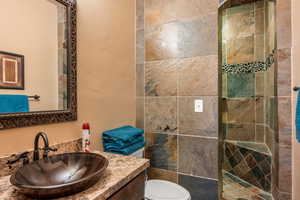 Full bath with a textured wall, vanity, and a walk in shower