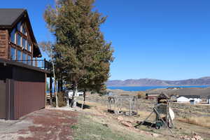 View of yard featuring a water and mountain view and a balcony