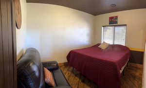 Bedroom with hardwood / wood-style floors and baseboards