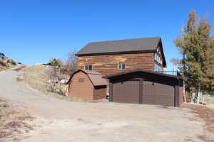 View of front of home featuring an outbuilding, driveway, and a garage