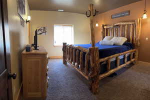 Bedroom with baseboards and dark carpet