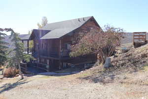 View of property exterior with a deck and a shingled roof