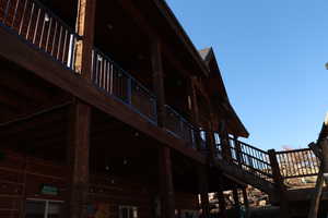 View of property exterior with a wooden deck and stairs